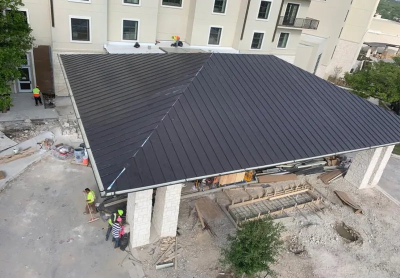 Metal roofing installation team working on a commercial building in Tysons